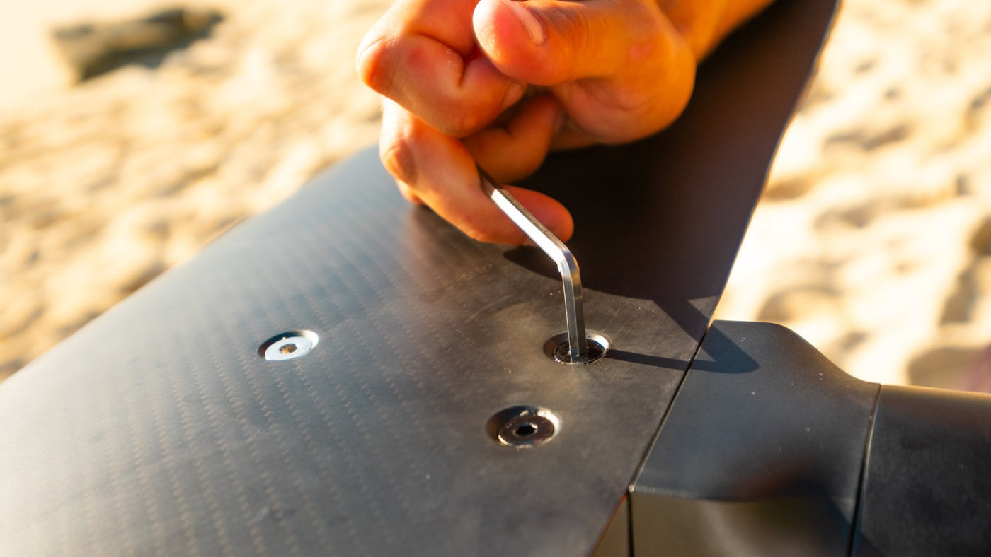 Llave allen apretando un tornillo del fuselaje de carbono de un Flyer EVO, sobre arena