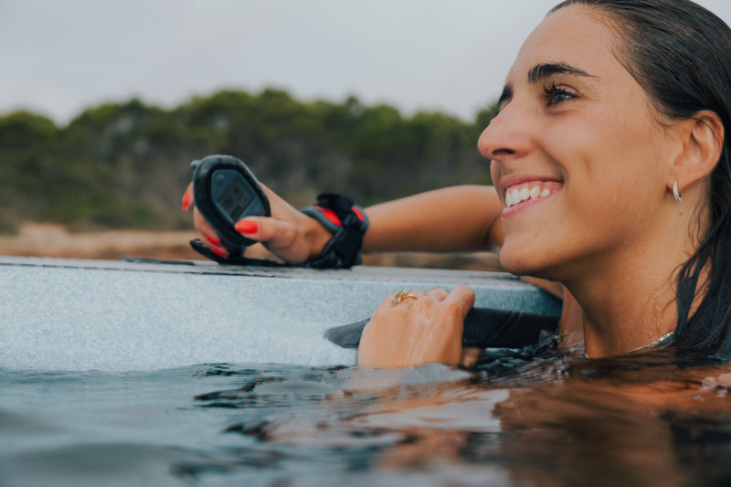 Dos mujeres sonriéndose en el agua sujetando Subnados