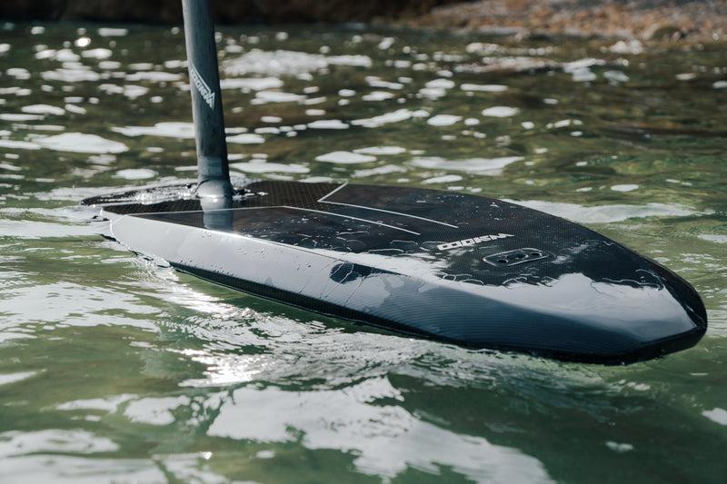 Tabla Flyer EVO flotando, detalle de la punta de carbono reflejada en el agua