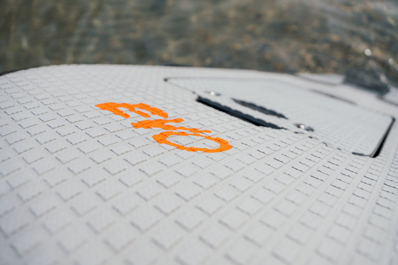 Primer plano del logo naranja EVO sobre el grip pad de la tabla