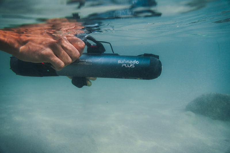 Primer plano bajo el agua de una mano sujetando el Subnado